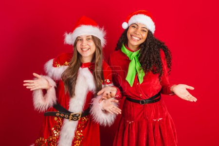 Photo for Two Brazilian friends, dressed in Christmas clothes, with open arms, welcoming. - Royalty Free Image
