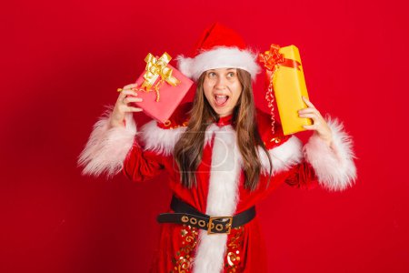 Téléchargez les photos : Caucasienne, Brésilienne en vêtements de Noël, Père Noël. tenant deux cadeaux. - en image libre de droit