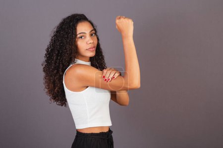 Photo for Young black Brazilian woman, with raised and closed fist, militancy, feminism. - Royalty Free Image