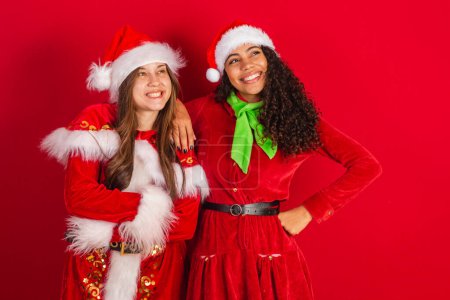 Photo for Two brazilian female friends, dressed in christmas clothes, santa claus, - Royalty Free Image