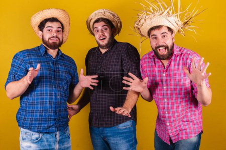 Photo for Three friends wearing typical clothes for the Festa Junina. Amazed, surprised, unbelievable. - Royalty Free Image