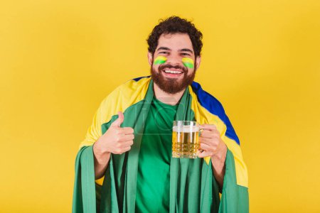 Photo for Caucasian man with beard, brazilian, soccer fan from brazil, liking and approving a beer. - Royalty Free Image