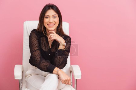 Foto de Hermosa mujer brasileña caucásica, fondo rosa, espacio para anuncio y publicidad, foto horizontal Sentado en silla de oficina. - Imagen libre de derechos