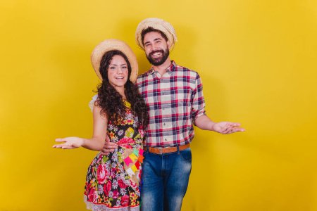 Photo for Beautiful couple dressed in typical clothes for a Festa Junina. Arraia de Sao Joao. Be welcome. welcoming. - Royalty Free Image
