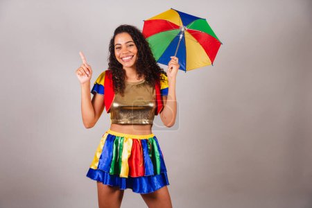 Photo for Beautiful black Brazilian woman, with frevo outfit, and umbrella, carnival. Dancing frevo, typical Brazilian carnival dance. - Royalty Free Image