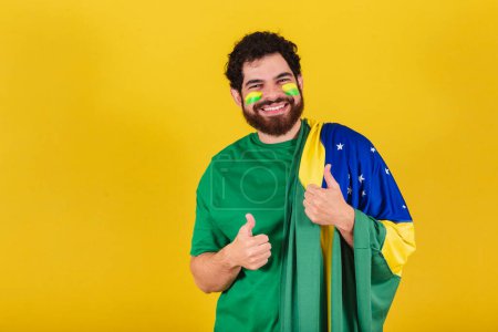 Photo for Caucasian man with beard, brazilian, soccer fan from brazil, thumb up, positive, like, approval. - Royalty Free Image