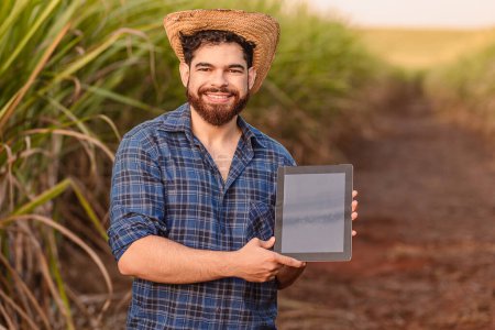 Photo for Brazilian caucasian man, farmer, rural worker, agricultural engineer, showing tablet screen, technology and agriculture. - Royalty Free Image