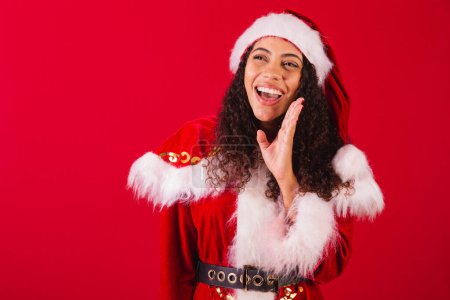 Photo for Beautiful brazilian black woman, dressed as santa claus, christmas clothes. screaming promotion. - Royalty Free Image