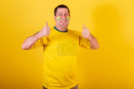Téléchargez les photos : Homme adulte, fan de football brésilien, comme signe avec les mains. approbation, affirmative. - en image libre de droit