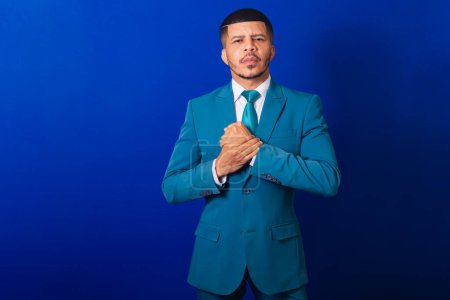 Foto de Hombre negro brasileño, vestido con traje y corbata azul. hombre de negocios. con los brazos cruzados, cara seria. - Imagen libre de derechos