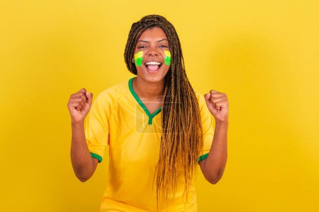 Photo for Young brazilian soccer fan woman. celebrating, vibrating. Brazil soccer team. - Royalty Free Image