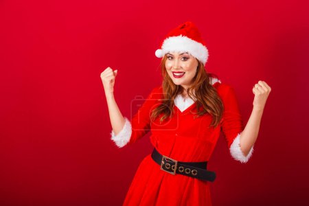 Photo for Beautiful Brazilian red-haired woman, dressed in Christmas clothes, Santa Claus. celebrating. - Royalty Free Image