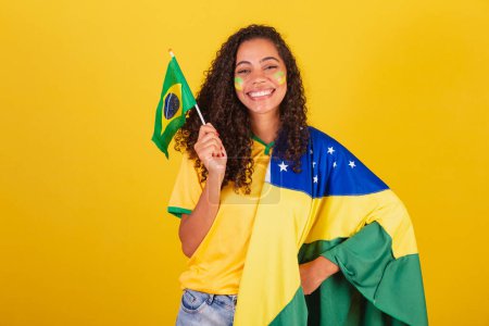 Photo for Young black Brazilian woman, soccer fan. waving flag, patriotic, nationalist. - Royalty Free Image