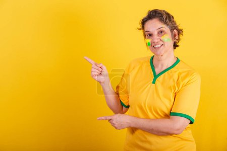 Photo for Adult adult woman, brazil soccer fan, pointing left, publicity photo. - Royalty Free Image