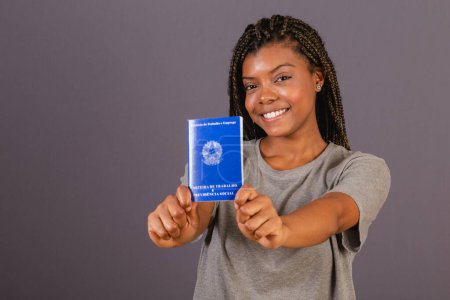 Foto de Joven mujer afro brasileña con carnet de trabajo y seguridad social. Documento oficial, Recursos humanos, mercado laboral. - Imagen libre de derechos