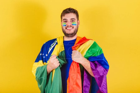 Téléchargez les photos : Homme caucasien brésilien, fan de football brésilien, drapeau LGBT, concept d'égalité des sexes, diversité. Sexualité - en image libre de droit