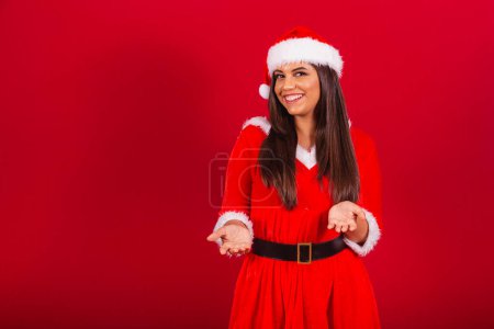 Foto de Hermosa mujer brasileña vestida con ropa de Navidad, Santa Claus. invitando a las manos. - Imagen libre de derechos