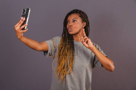 Photo for Young afro brazilian woman taking self portrait, selfie, photo, social networks. smartphone. - Royalty Free Image