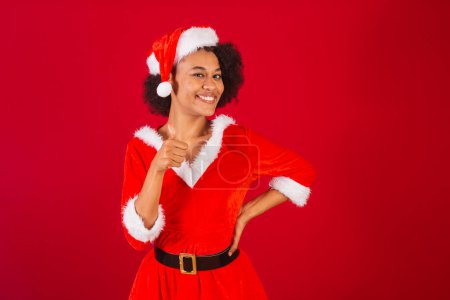 Téléchargez les photos : Belle femme brésilienne noire, habillée en Père Noël claus, maman claus, genre, pouce levé - en image libre de droit