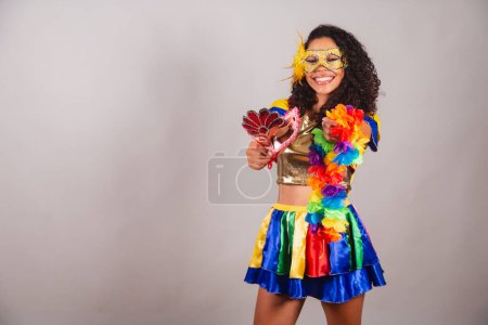 Foto de Hermosa mujer brasileña negra, con ropa frevo, carnaval. Usando máscara, sosteniendo máscara y collar - Imagen libre de derechos