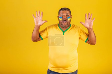 Téléchargez les photos : Homme noir brésilien, fan de football brésilien. surpris, wow, incroyable, incroyable. - en image libre de droit
