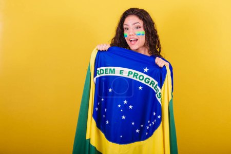 Foto de Mujer fanática del fútbol, fan de Brasil, copa del mundo, sosteniendo bandera y mostrando orden y progreso. - Imagen libre de derechos