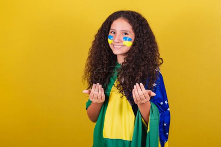 Téléchargez les photos : Brésilien, Caucasien, fan de football fille, disant venez, venez, ici, invitant avec les mains, appelant avec les mains. - en image libre de droit