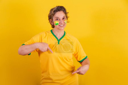 Téléchargez les photos : Adulte femme adulte, fan de football brésilien, pointant vers le centre, seulement ici. - en image libre de droit