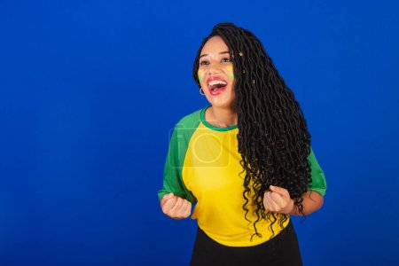 Photo for Young black Brazilian woman, soccer fan. celebrating and celebrating. - Royalty Free Image