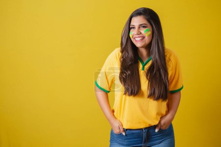 Foto de Mujer partidaria de Brasil, copa del mundo 2022, campeonato de fútbol, manos en los bolsillos sonriendo. - Imagen libre de derechos