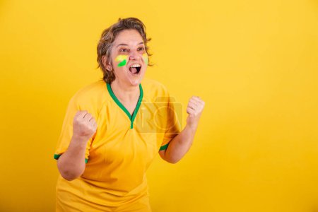 Téléchargez les photos : Adulte femme adulte, fan de football du Brésil, acclamant et criant objectif. - en image libre de droit