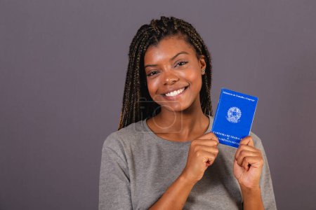 Photo for Young afro brazilian woman holding work card and social security. Official document, Human resources, labor market. - Royalty Free Image