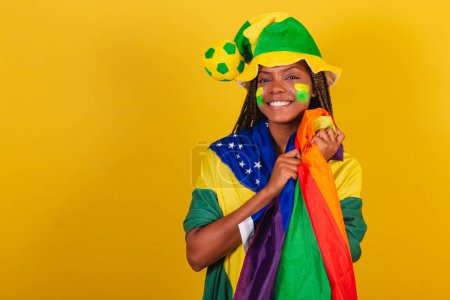 Photo for Black woman young brazilian soccer fan. Holding LGBTQ Flag, Militancy, LGBT Pride, lesbian. diversity. - Royalty Free Image