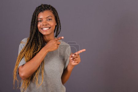 Photo for Young afro brazilian woman pointing with fingers to the right. Photo for ad. Advertising. - Royalty Free Image