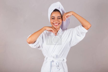 Photo for Beautiful Brazilian black woman, wearing bathrobe and towel. close-up photo, spa, aesthetics, showing beauty, delicacy. welfare. - Royalty Free Image