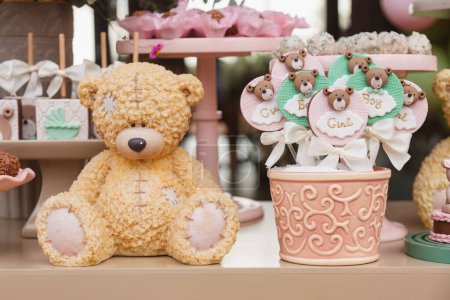 Téléchargez les photos : Ours en peluche décoration pour bébé genre révéler le thé. avec sucettes au chocolat, sucreries brésiliennes typiques. - en image libre de droit