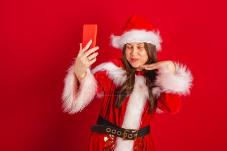 Photo for Caucasian, Brazilian woman in Christmas clothes, Santa Claus. self portrait by smartphone. - Royalty Free Image