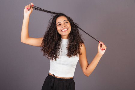 Téléchargez les photos : Jeune femme noire brésilienne, violon avec les cheveux, boucles, bouclés, cheveux afro. tirant les cheveux - en image libre de droit