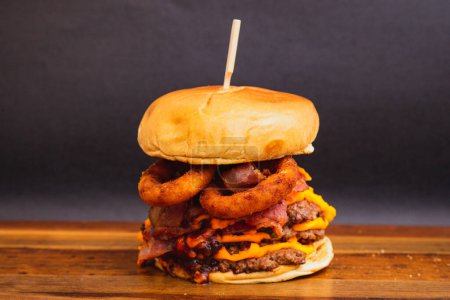Téléchargez les photos : Délicieux double burger de bœuf, fromage cheddar, bacon et rondelles d'oignons frits. - en image libre de droit