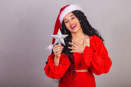 Foto de Mujer negra brasileña vistiendo ropa de navidad, feliz Navidad, sonriendo, estrella de celebración, decoración de navidad - Imagen libre de derechos