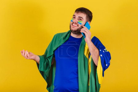 Photo for Brazilian caucasian man, soccer fan from Brazil, chatting voice call on his cellphone, selfie. smartphone - Royalty Free Image
