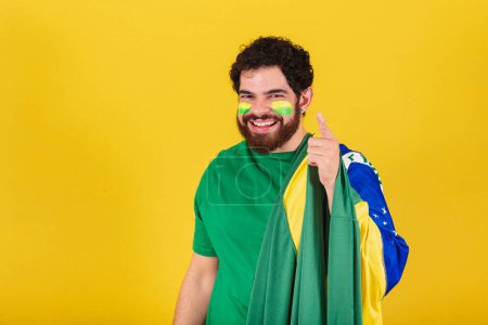 Photo for Caucasian man with beard, brazilian, soccer fan from brazil, advising, suggesting, indicating, pointing at camera. Choosing you. - Royalty Free Image