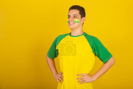 Photo for Young Brazilian man soccer fan. dressed in green, and yellow, hands on hips. - Royalty Free Image