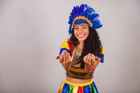Foto de Hermosa mujer brasileña negra, con ropa frevo, carnaval. en tocado de plumas de carnaval. invitando a las manos. - Imagen libre de derechos