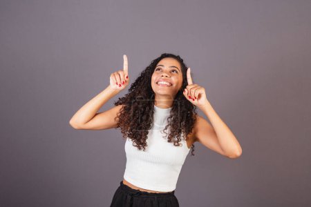 Photo for Young Brazilian black woman pointing up - Royalty Free Image