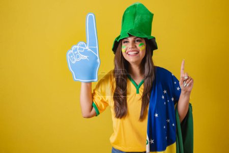 Photo for Woman supporter of Brazil, world cup 2022, dancing with foam finger. - Royalty Free Image