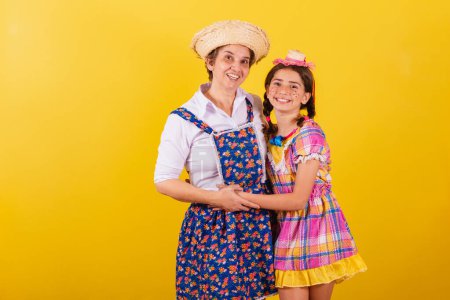 Photo for Grandmother and granddaughter dressed in typical Festa Junina clothes. hugging and smiling. - Royalty Free Image