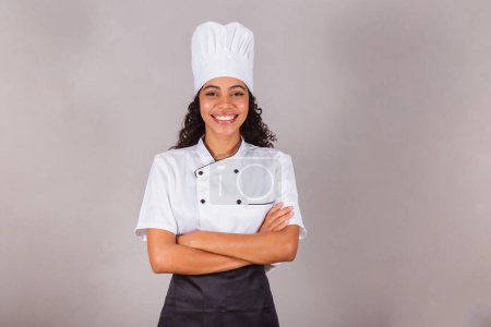 Téléchargez les photos : Jeune femme brésilienne noire, cuisinière, chef cuisinier. Les bras croisés. souriant. - en image libre de droit