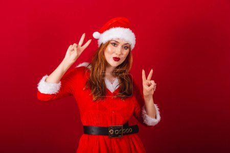 Photo for Beautiful Brazilian red-haired woman, dressed in Christmas clothes, Santa Claus. peace and love, posing for photo. - Royalty Free Image