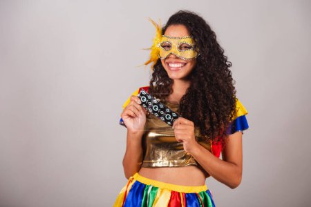 Téléchargez les photos : Belle femme brésilienne noire, avec des vêtements frevo, carnaval. port d'un masque, tenue d'un préservatif, lutte contre le VIH, aides. - en image libre de droit